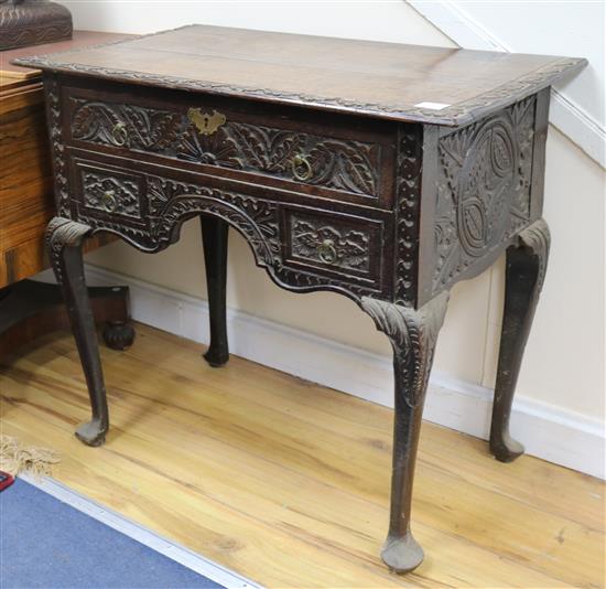 An early 18th century style carved oak lowboy, W.85cm